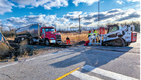 A skid steer is pictured being used to pull a tractor trailer off the railway tracks. (Photo courtesy Collin Vandenheuvel)